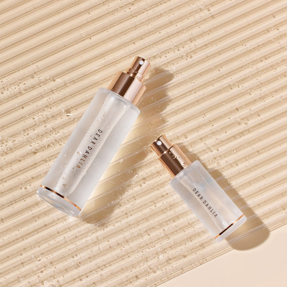 Skincare bottle with rose gold cap and base on a white background  AgelessBeautz3000.com  DEAR DAHLIA |  Endless Skin Setting Spray