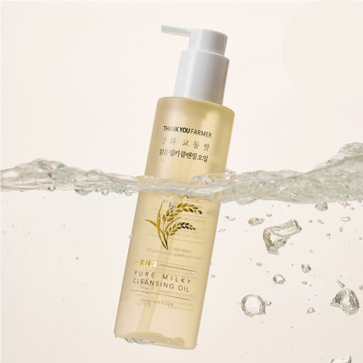 AgelessBeauty3000.com Two bottles of Thank You Farmer rice pure milky cleansing oil with water droplets on a light background.