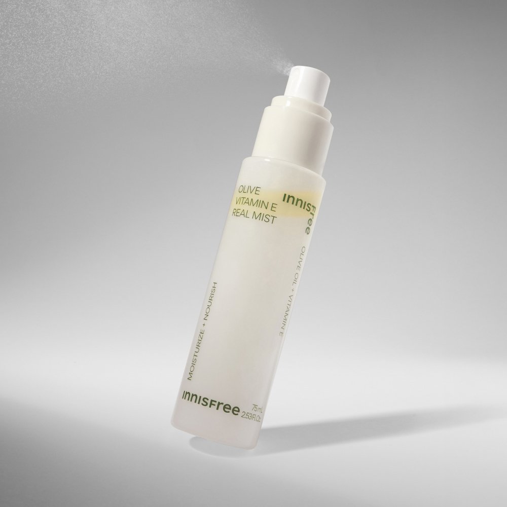ThatKBeautyShop.com  innisfree | Olive Vitamin E Real Mist    Innisfree Olive Vitamin E Real Mist spray bottle, featuring a frosted white body and a white pump dispenser, set against a clean gray gradient background with a subtle mist effect.