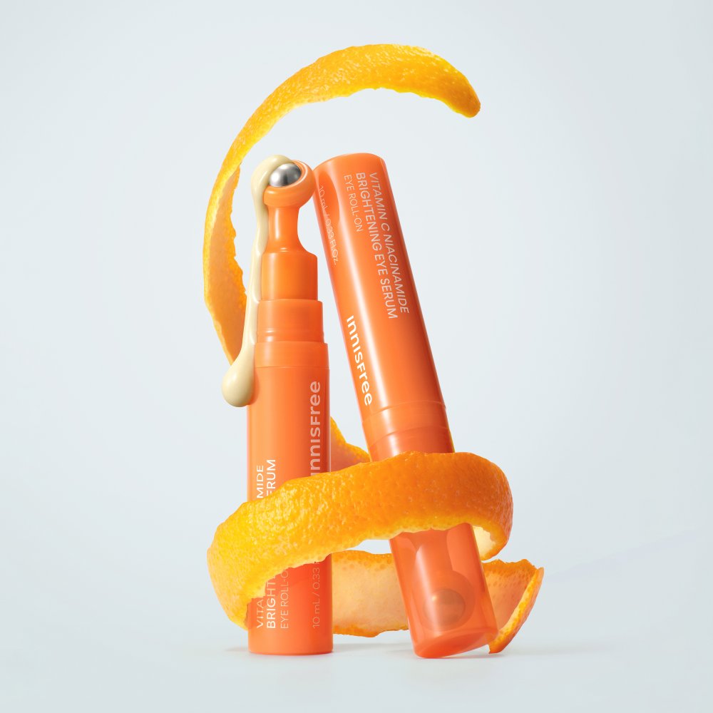 ThatKBeautyShop.com      Innisfree Vitamin C Niacinamide Brightening Eye Serum   Two orange skincare products with an orange peel on a light gray background
